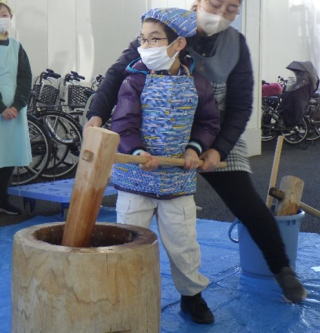 餅をつく様子。杵を持って臼に入った餅をついています。