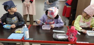 餅を食べる様子。児童たちが海苔餅やきな粉餅、お雑煮を食べています。